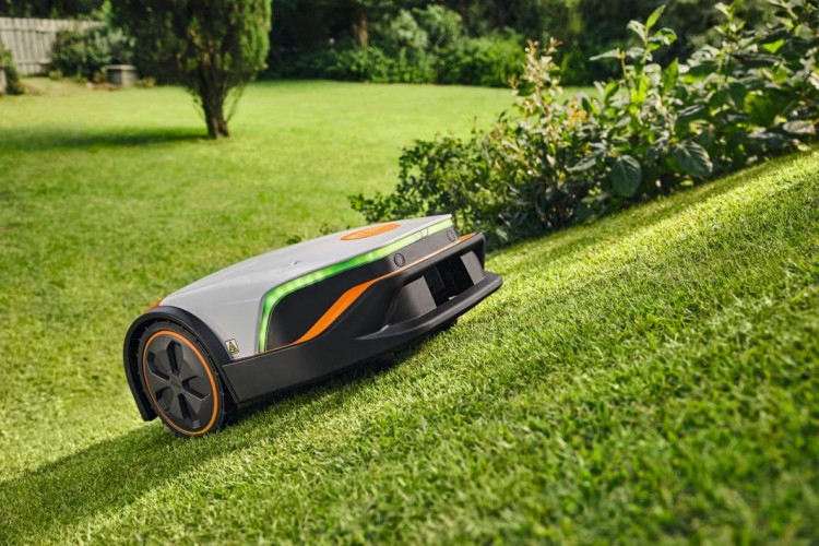 Automatyczna kosiarka STIHL iMOW 6 pracująca na trawniku z możliwością sterowania przez WiFi i Bluetooth.